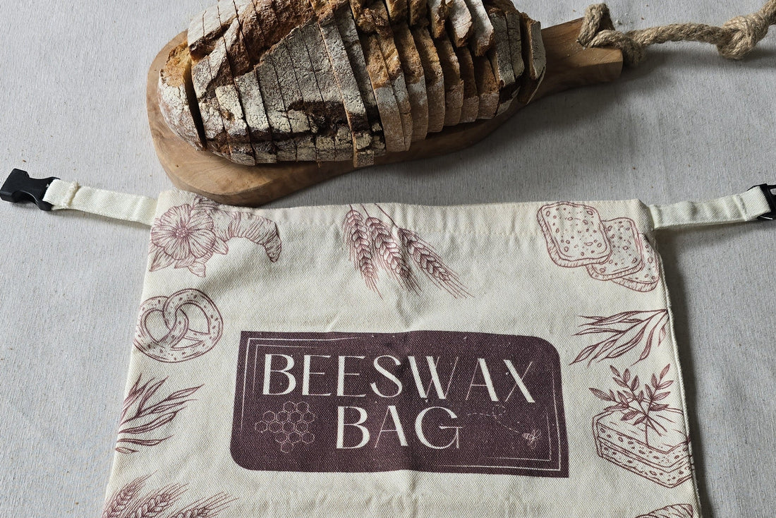 Gesneden brood op een houten snijplank naast een bijenwas broodzak