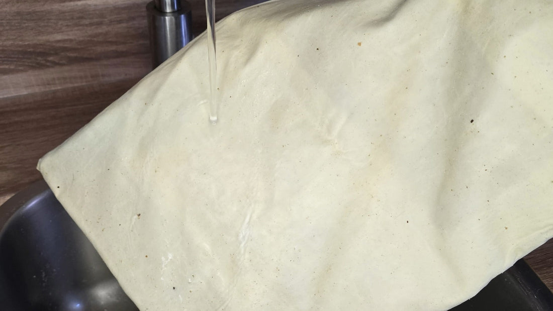 Bijenwas broodzak binnenstebuiten onder de koude kraan boven de gootsteen