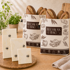 Bijenwas bewaarset met twee broodzakken gevuld met brood en drie wraps op een houten plank