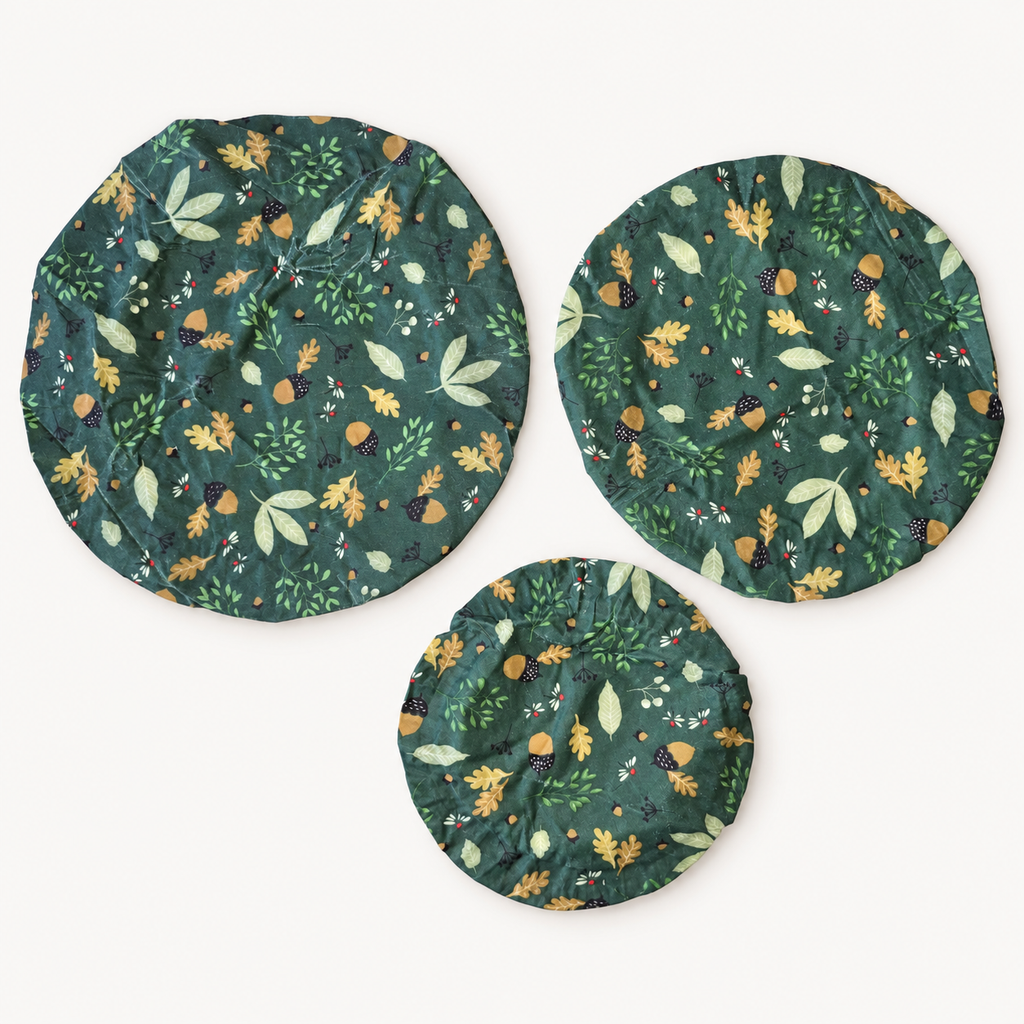 Set van drie bijenwas bowl covers met bosprint van bladeren en eikels op donkergroen, van bovenaf